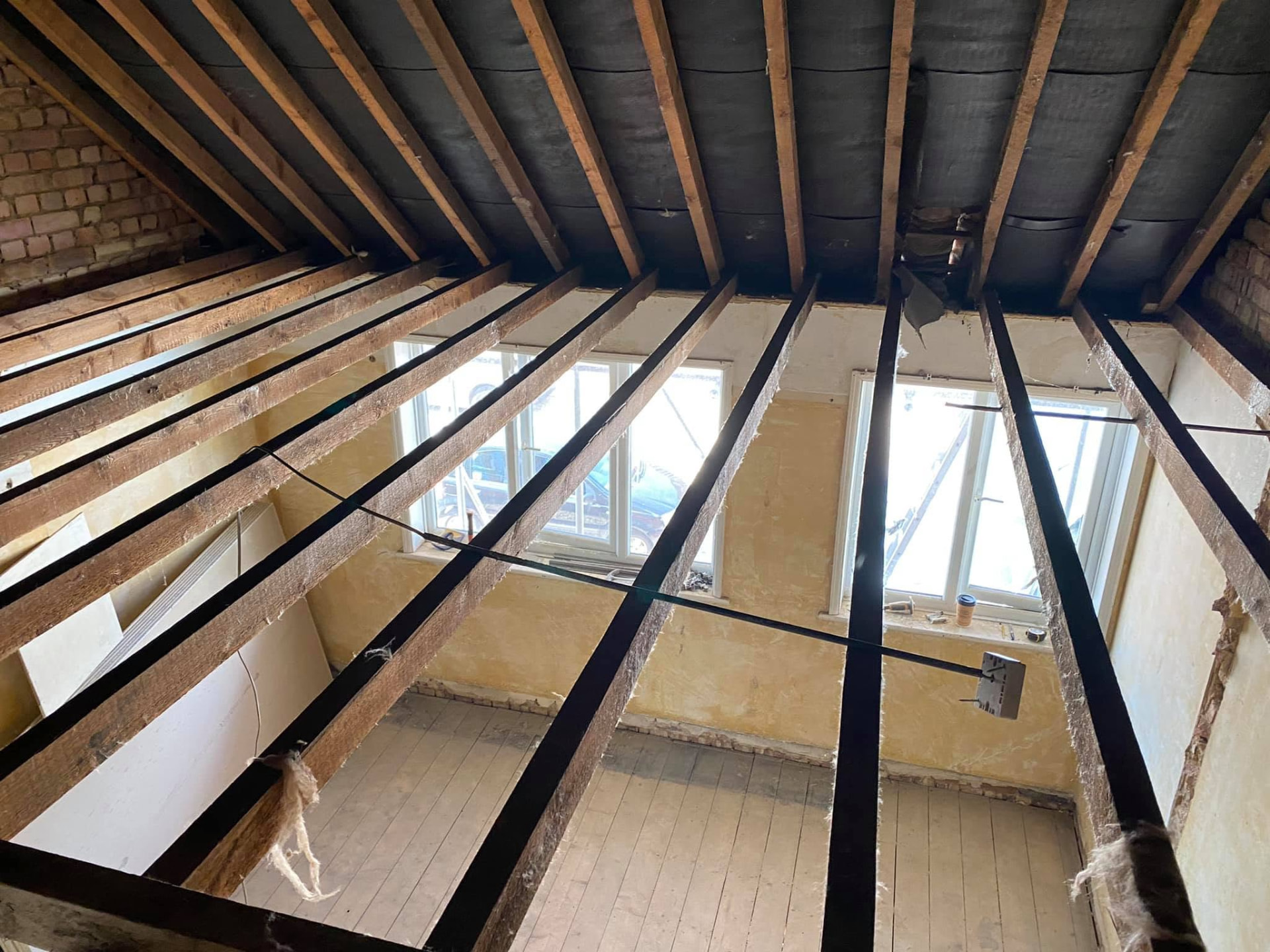 Structural renovation project with new timber joists installed across an exposed ceiling