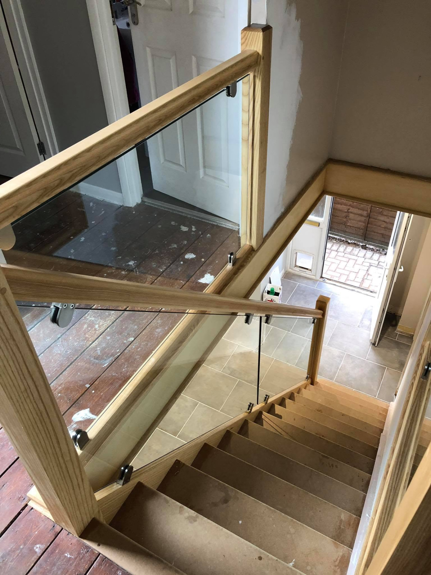 Bespoke oak and glass balustrade fitted around a landing and staircase